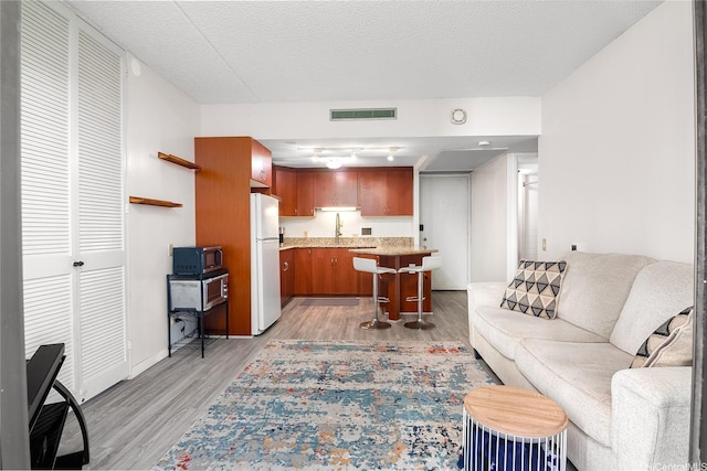 225 Queen St Unit 9E, Honolulu, HI 96813 - living room featuring light wood finished floors and a textured ceiling
