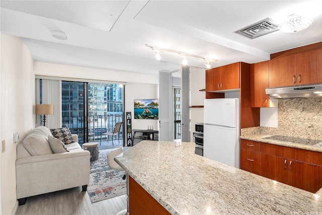 225 Queen St Unit 9E, Honolulu, HI 96813 - kitchen with stainless steel appliances, under cabinet range hood, brown cabinetry, and decorative backsplash