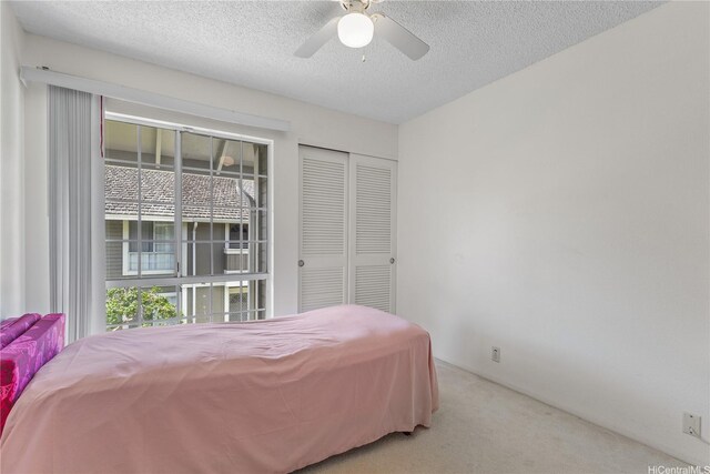 94-1359 Kulewa Loop Unit 16S, Waipahu, HI 96797 - carpeted bedroom with multiple windows, a textured ceiling, a closet, and a ceiling fan