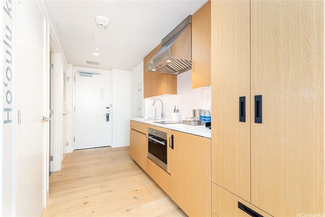 1390 Kapiolani Blvd Unit 3808, Honolulu, HI 96814 - kitchen with oven, light wood-type flooring, light countertops, wall chimney exhaust hood, and modern cabinets