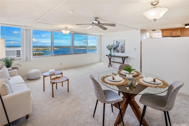 98-288 Kaonohi St Unit 3901, Aiea, HI 96701 - dining space with a textured ceiling, light colored carpet, a ceiling fan, and a water view