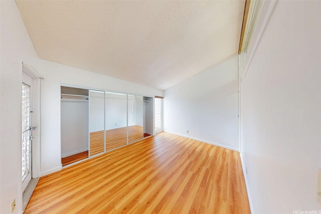 95-312 Kahikinui Ct Unit 213, Mililani, HI 96789 - unfurnished bedroom with wood finished floors, lofted ceiling, multiple windows, and a textured ceiling