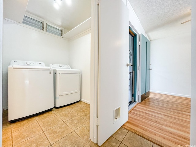 95-312 Kahikinui Ct Unit 213, Mililani, HI 96789 - laundry room featuring washing machine and dryer, light tile patterned floors, and a textured ceiling