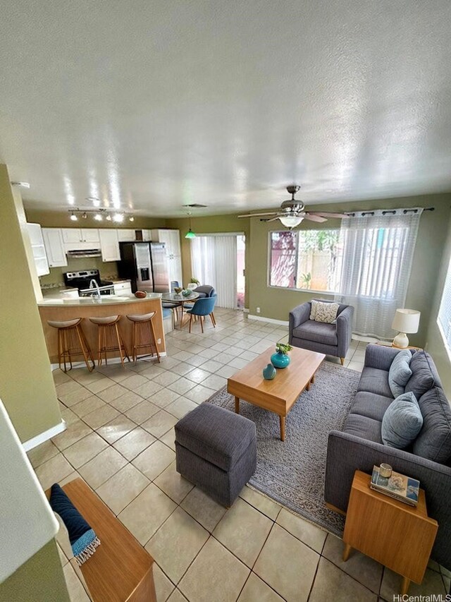 91-280 Makalea St Unit 23, Ewa Beach, HI 96706 - living area with light tile patterned flooring, ceiling fan, and a textured ceiling