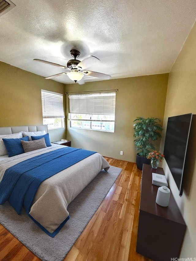 91-280 Makalea St Unit 23, Ewa Beach, HI 96706 - bedroom with a textured ceiling, light wood-type flooring, and a ceiling fan