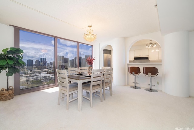 425 S St Unit 2401, Honolulu, HI 96813 - carpeted dining space featuring a chandelier, arched walkways, and a view of skyline