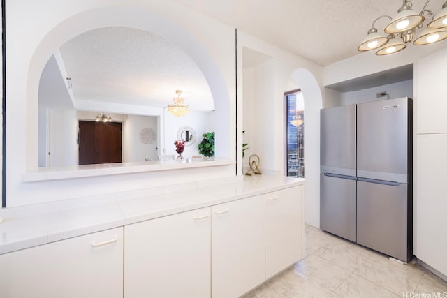 425 S St Unit 2401, Honolulu, HI 96813 - kitchen with freestanding refrigerator, arched walkways, a chandelier, light countertops, and a textured ceiling