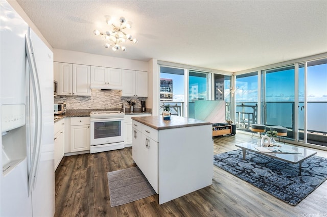 801 S St Unit 3822, Honolulu, HI 96813 - kitchen featuring white appliances, dark countertops, a center island, dark wood-style floors, and a textured ceiling