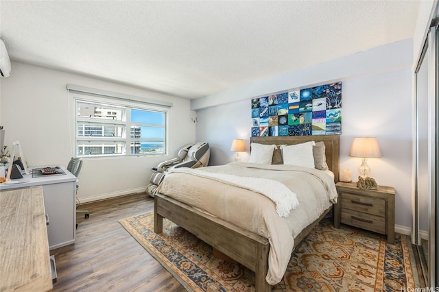 801 S St Unit 3822, Honolulu, HI 96813 - bedroom with wood finished floors, a textured ceiling, an office area, and a wall mounted air conditioner