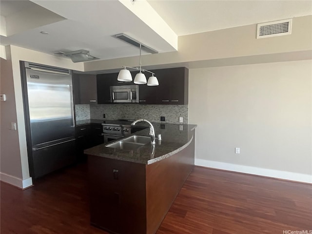 1837 Kalakaua Ave Unit 1103, Honolulu, HI 96815 - kitchen with premium appliances, a peninsula, decorative backsplash, and dark wood-style flooring