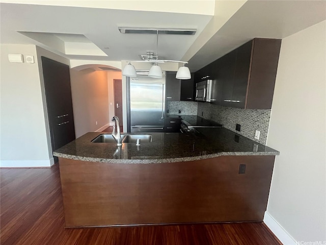 1837 Kalakaua Ave Unit 1103, Honolulu, HI 96815 - kitchen featuring arched walkways, appliances with stainless steel finishes, dark wood-style floors, a peninsula, and decorative backsplash