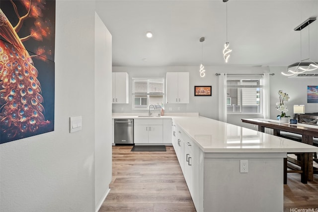 91-1775 Kohanahana Loop, Ewa Beach, HI 96706 - kitchen with stainless steel dishwasher, light wood-style flooring, white cabinetry, light countertops, and a peninsula