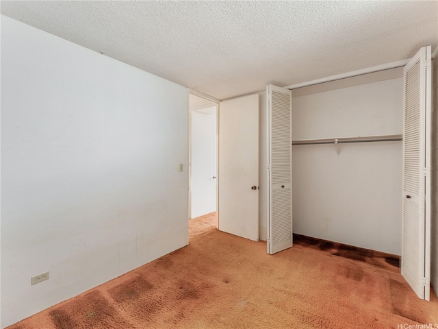 1160 Ala Napunani St Unit 1407, Honolulu, HI 96818 - unfurnished bedroom featuring carpet, a closet, and a textured ceiling