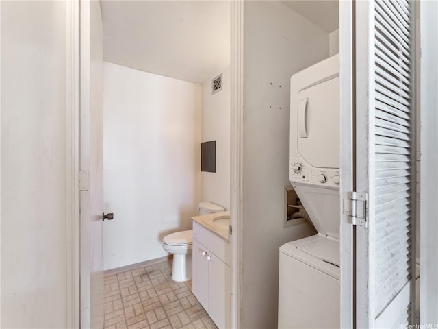 1160 Ala Napunani St Unit 1407, Honolulu, HI 96818 - laundry area with stacked washer / dryer and brick patterned floors
