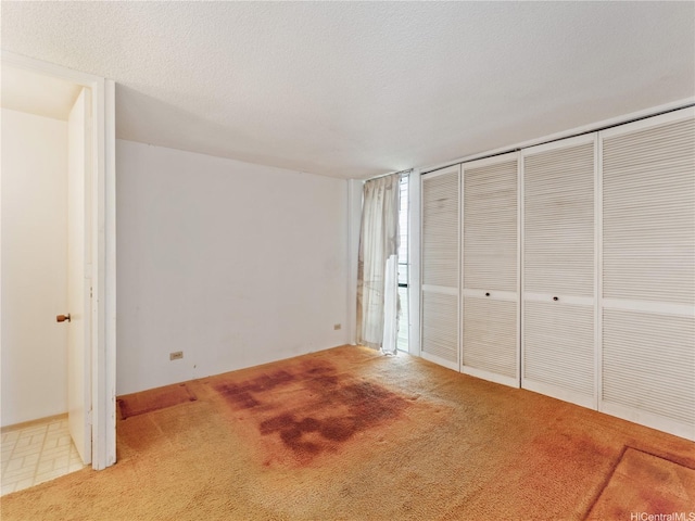 1160 Ala Napunani St Unit 1407, Honolulu, HI 96818 - unfurnished bedroom featuring carpet flooring, a closet, and a textured ceiling