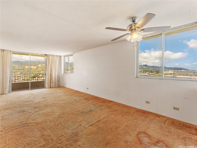 1160 Ala Napunani St Unit 1407, Honolulu, HI 96818 - carpeted empty room with healthy amount of natural light, a textured ceiling, a ceiling fan, and expansive windows