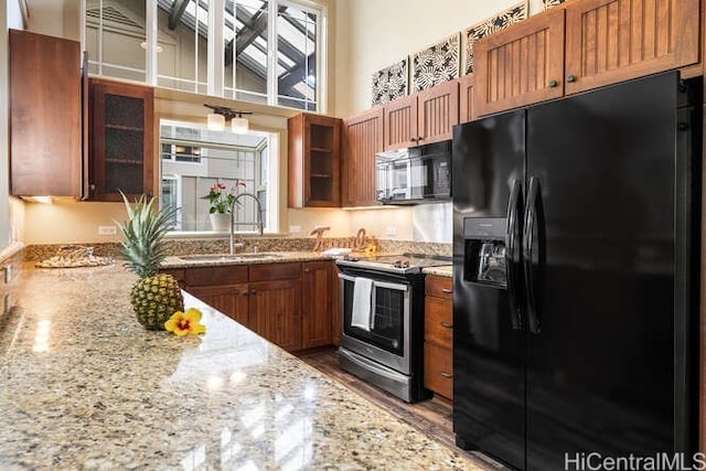 75-6025 Alii Dr Unit L201, Kailua Kona, HI 96740 - kitchen with black appliances, brown cabinetry, glass insert cabinets, and a high ceiling