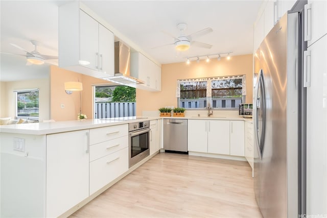 341 Opihikao Pl Unit 422, Honolulu, HI 96825 - kitchen featuring appliances with stainless steel finishes, ceiling fan, wall chimney exhaust hood, and track lighting