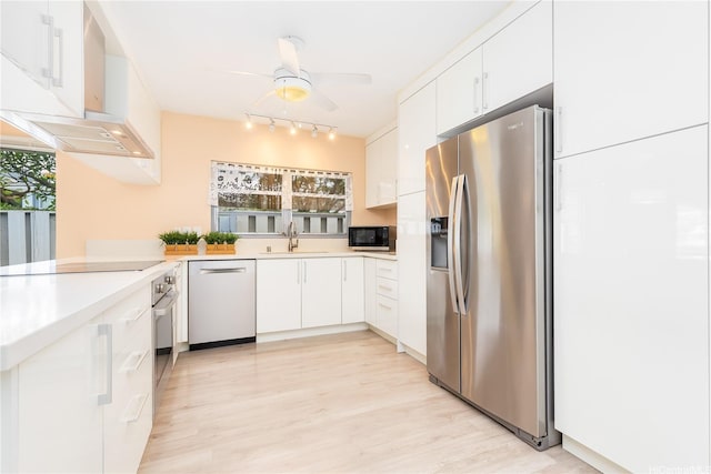 341 Opihikao Pl Unit 422, Honolulu, HI 96825 - kitchen with black appliances, track lighting, wall chimney range hood, and white cabinetry