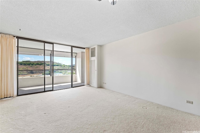 1717 Mott Smith Dr Unit 2212, Honolulu, HI 96822 - unfurnished room featuring carpet flooring, a textured ceiling, and a wall of windows