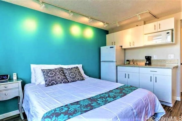 444 Niu St Unit 3608, Honolulu, HI 96815 - bedroom featuring track lighting, freestanding refrigerator, and dark wood-style flooring