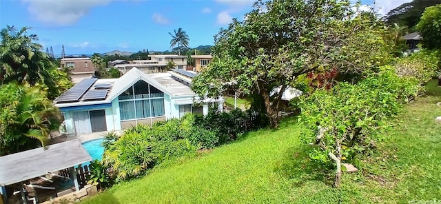 46-046 Puulau Pl, Kaneohe, HI 96744 - back of house featuring a lawn and roof mounted solar panels