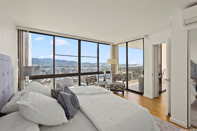 990 Ala Nanala St Unit 35B, Honolulu, HI 96818 - bedroom with a wall of windows, an AC wall unit, access to exterior, light wood finished floors, and a city view