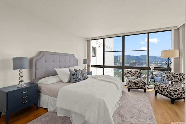 990 Ala Nanala St Unit 35B, Honolulu, HI 96818 - bedroom featuring expansive windows, wood finished floors, and a city view