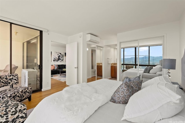 990 Ala Nanala St Unit 35B, Honolulu, HI 96818 - bedroom with an AC wall unit, wood finished floors, and a mountain view
