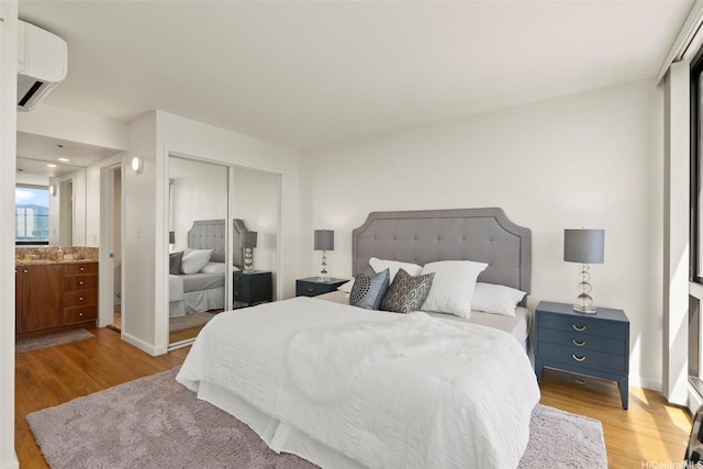 990 Ala Nanala St Unit 35B, Honolulu, HI 96818 - bedroom with a wall unit AC, wood finished floors, and a closet