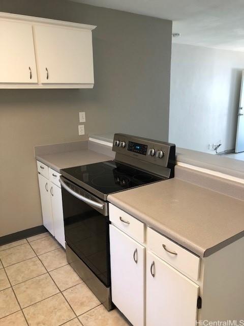 94010 Leolua St Unit 215, Waipahu, HI 96797 - kitchen featuring electric stove, white cabinetry, light tile patterned floors, and light countertops