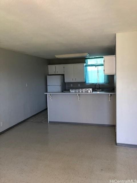 94010 Leolua St Unit 215, Waipahu, HI 96797 - kitchen with freestanding refrigerator, white cabinetry, and a peninsula