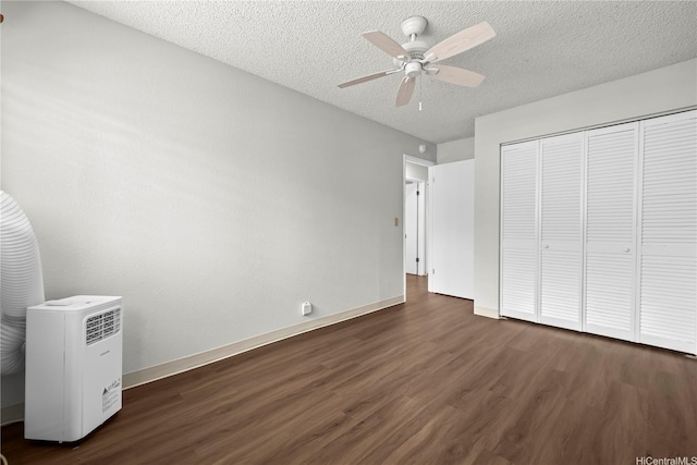 46-263 Kahuhipa St Unit B303, Kaneohe, HI 96744 - unfurnished bedroom featuring dark wood finished floors, a textured ceiling, a closet, and a ceiling fan