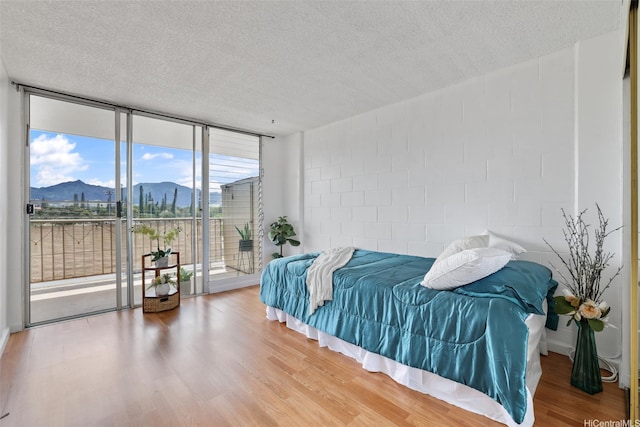 1830 Wilikina Dr Unit 602, Wahiawa, HI 96786 - bedroom featuring a mountain view, access to exterior, expansive windows, a textured ceiling, and wood finished floors