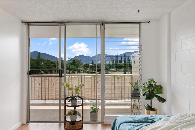 1830 Wilikina Dr Unit 602, Wahiawa, HI 96786 - bedroom with wood finished floors, a mountain view, multiple windows, floor to ceiling windows, and a textured ceiling