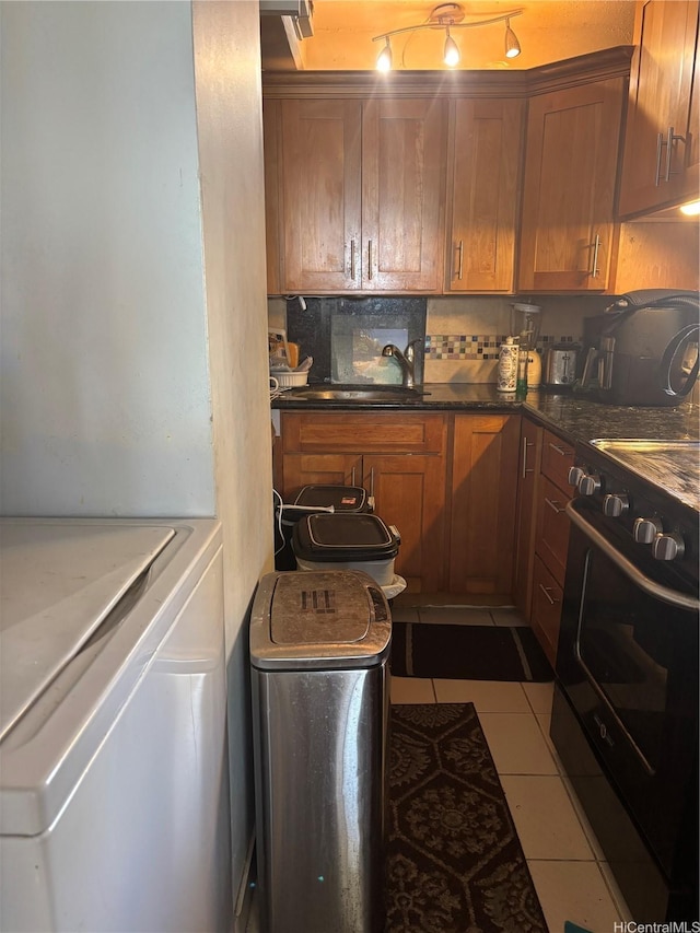 2333 Kapiolani Blvd Unit 1008, Honolulu, HI 96826 - kitchen with stove, washer / clothes dryer, tile patterned flooring, brown cabinetry, and decorative backsplash