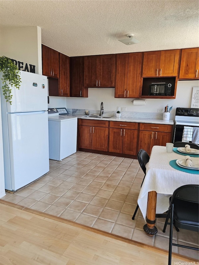1702 Kewalo St Unit 204, Honolulu, HI 96822 - kitchen featuring black appliances, washer / dryer, light countertops, a textured ceiling, and light tile patterned flooring