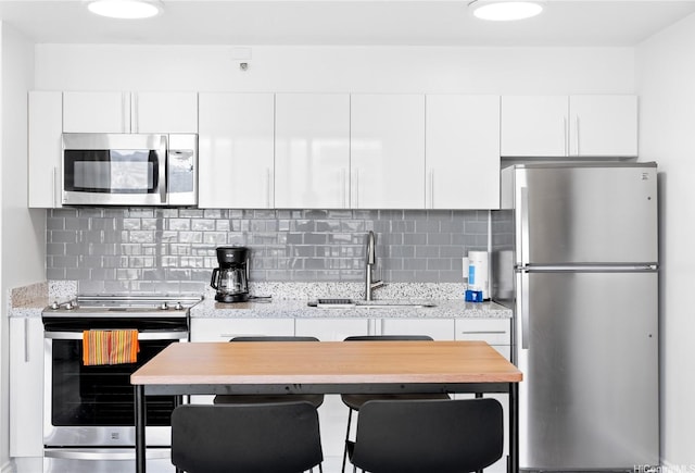 201 Oahu Ave Unit 1111, Honolulu, HI 96815 - kitchen featuring appliances with stainless steel finishes, white cabinetry, and decorative backsplash