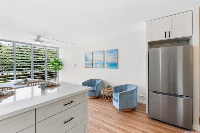 53-549 Kamehameha Hwy Unit 313, Hauula, HI 96717 - kitchen featuring freestanding refrigerator, ceiling fan, light countertops, light wood-type flooring, and white cabinetry
