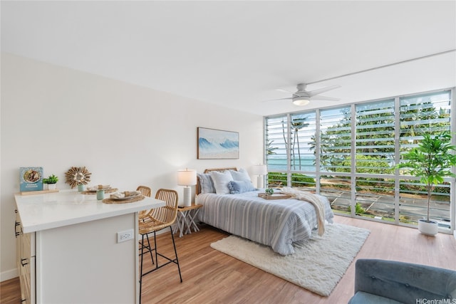 53-549 Kamehameha Hwy Unit 313, Hauula, HI 96717 - bedroom with light wood-style floors, expansive windows, and a ceiling fan