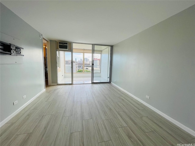 1556 Piikoi St Unit 506, Honolulu, HI 96822 - unfurnished room with a wall of windows, light wood-type flooring, and a wall mounted AC