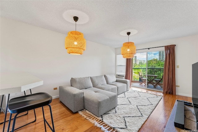 3075 Ala Poha Pl Unit 206, Honolulu, HI 96818 - living area featuring a textured ceiling and wood finished floors