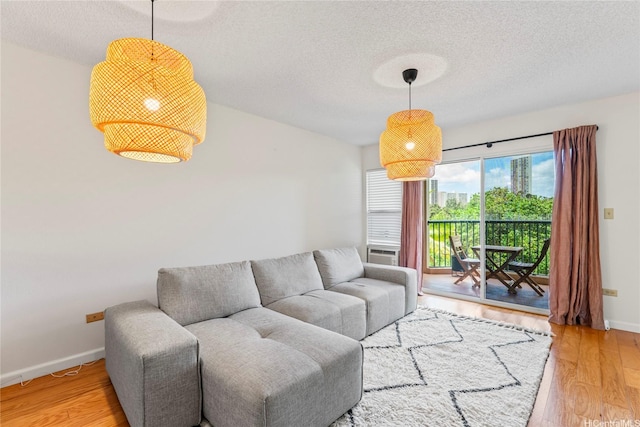 3075 Ala Poha Pl Unit 206, Honolulu, HI 96818 - living area featuring a textured ceiling and light wood-style flooring