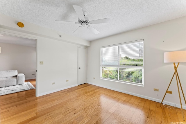3075 Ala Poha Pl Unit 206, Honolulu, HI 96818 - unfurnished bedroom with a textured ceiling, light wood-style flooring, and a ceiling fan