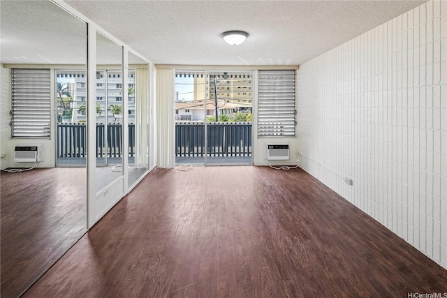 1605 Pensacola St Unit 104, Honolulu, HI 96822 - unfurnished living room with a textured ceiling, wood finished floors, a wall mounted AC, and a wall unit AC