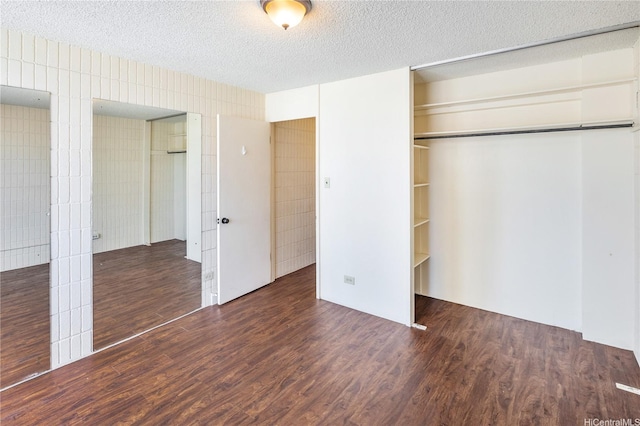 1605 Pensacola St Unit 104, Honolulu, HI 96822 - unfurnished bedroom featuring wood finished floors, a textured ceiling, and tile walls