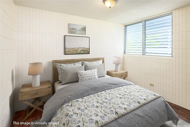 1605 Pensacola St Unit 104, Honolulu, HI 96822 - bedroom featuring tile walls, wood finished floors, and a textured ceiling