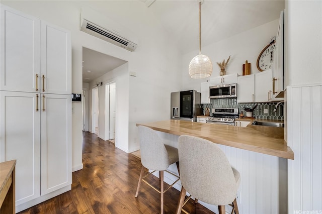 91-1516 Keonekapu St, Ewa Beach, HI 96706 - kitchen with stainless steel appliances, dark wood-style flooring, a peninsula, decorative backsplash, and a wall mounted air conditioner