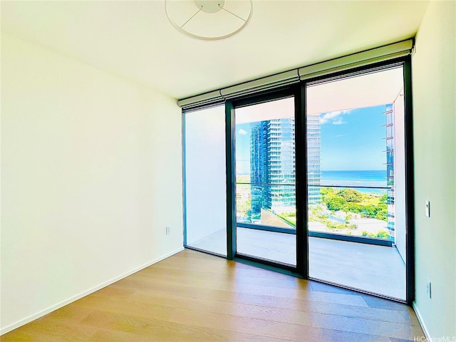 1000 Auahi St Unit 1600, Honolulu, HI 96814 - empty room with expansive windows, wood finished floors, and a water view