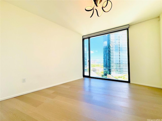 1000 Auahi St Unit 1600, Honolulu, HI 96814 - unfurnished room with expansive windows, a chandelier, and wood finished floors